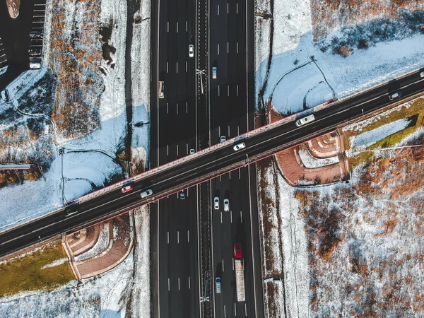 Vista aérea de carretera y puente, tráfico por carretera, bosques y campos cubiertos de nieve, invierno. Rusia, San Petersburgo . — Foto de Stock