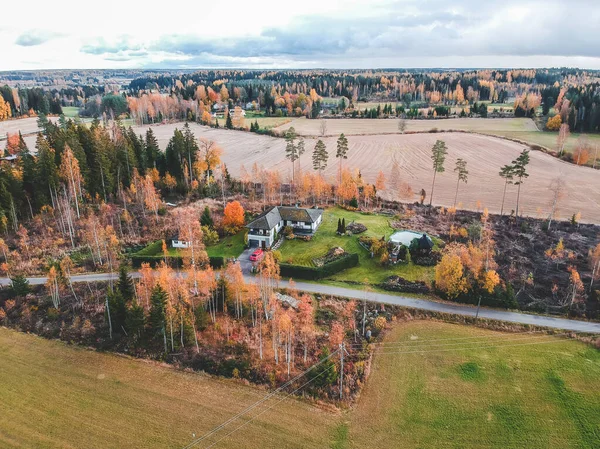 Vedere aeriană a unei case de țară în pădure, copaci și drum. Fotografie făcută dintr-o dronă. Finlanda, Pornainen . — Fotografie, imagine de stoc