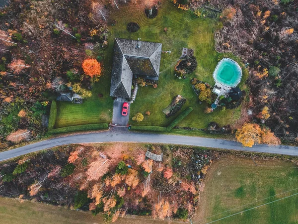 Vista aérea de uma casa de campo na floresta, nas árvores e na estrada. Foto tirada de um drone. Finlândia, Pornainen . — Fotografia de Stock Grátis