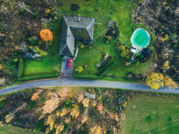 Flygfoto över ett hus på landet i skogen, träden och vägen. Fotot är taget från en drönare. Finland, Pornainen. — Stockfoto