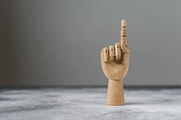 Houten hand toont één opgeheven vinger. Het begrip communicatie — Stockfoto