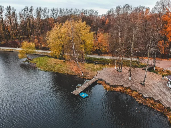 Повітряний вид пірс з дерев'яними човнами на березі мальовничого озера, осінній ліс. Санкт - Петербург, Росія. — стокове фото