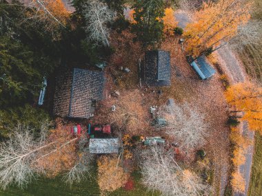 Ormanın ortasındaki hava tarlası, traktör ve ahırlar. Fotoğraf bir İHA 'dan çekildi. Finlandiya, Pornainen.