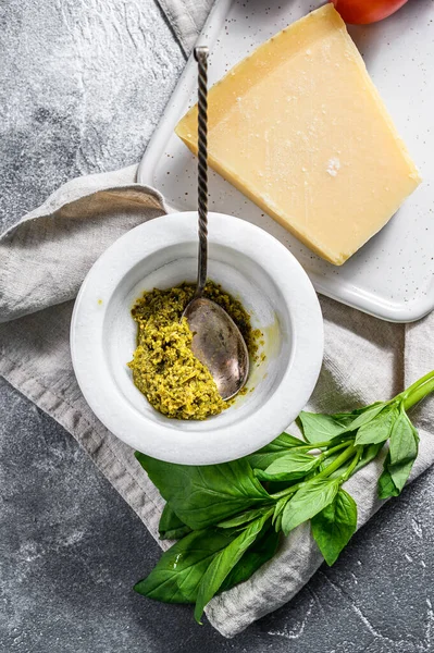 Hemlagad Pesto i marmormurbruk, basilikablad och parmesan på en hackbräda. Plats för text — Stockfoto