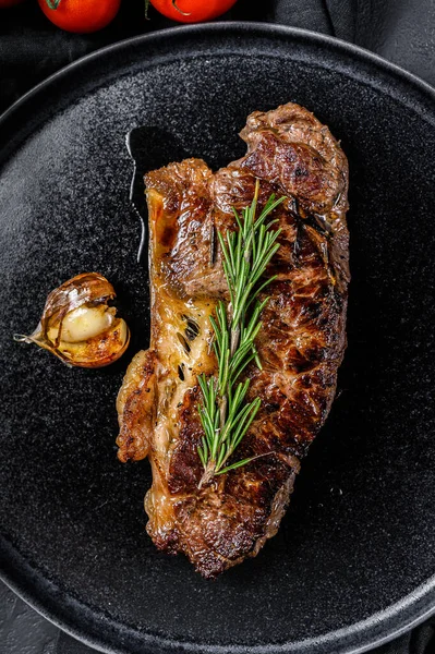 Beef sirloin steak on black background. Space for text. Marble premium beef. Close up.
