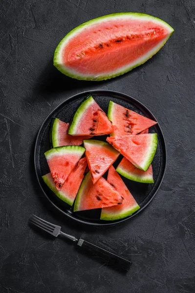 Scheiben reife Wassermelone in einem Teller auf dunklem Hintergrund. Selektiver Fokus. — Stockfoto