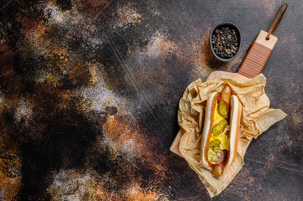 Hot dog with chicken sausage on a wooden cutting Board in Kraft paper, fast food restaurant menu concept. Junk food. Space for text