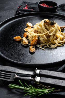 Siyah arka planda midyeli makarna. deniz ürünleri