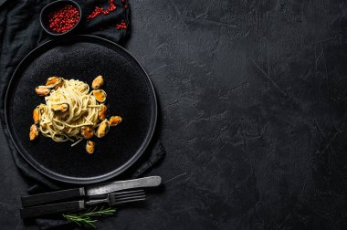 Ev yapımı midyeli makarna, siyah arka planda domates sosu. Deniz ürünleri. Metin için boşluk