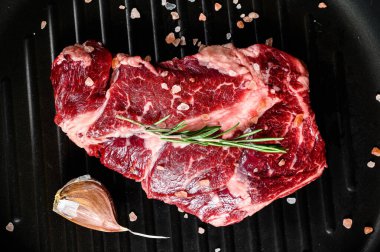 Kızartma tavasında mermer biftek. Organik çiftlik eti. Siyah arkaplan