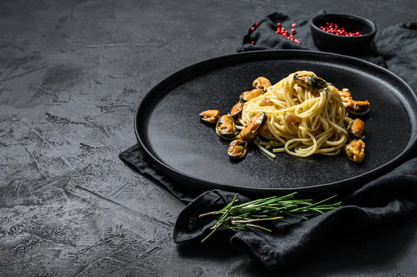 Spaghetti fatti in casa con cozze, sugo di pomodoro su fondo nero. farina di frutti di mare. spazio per il testo — Foto Stock