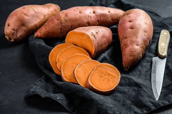 Rohe Süßkartoffeln, Bio-Batatas. Lebensmittel vom Bauernhof. schwarzer Hintergrund — Stockfoto