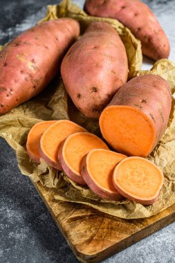 Doğrama tahtasında çiğ patates, organik yer elması. Çiftlik sebzeleri. Gri arkaplan