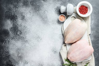 Çiğ tavuk göğsü, derili taze fileto. Organik çiftlik kuşu. Gri arka plan. Metin için boşluk