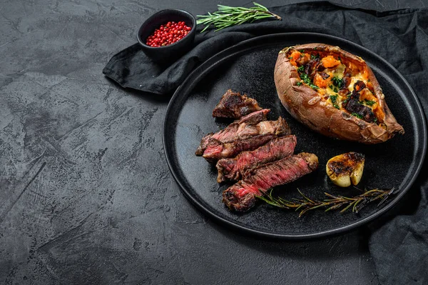 Steak de bœuf marbré avec garniture de patates douces cuites au four. Viande grillée. Viande de ferme biologique. Fond noir. Espace pour le texte . — Photo