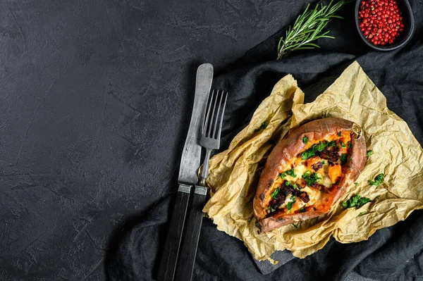 Papas dulces al horno rellenas de queso y tocino. Fondo negro. Espacio para texto — Foto de Stock