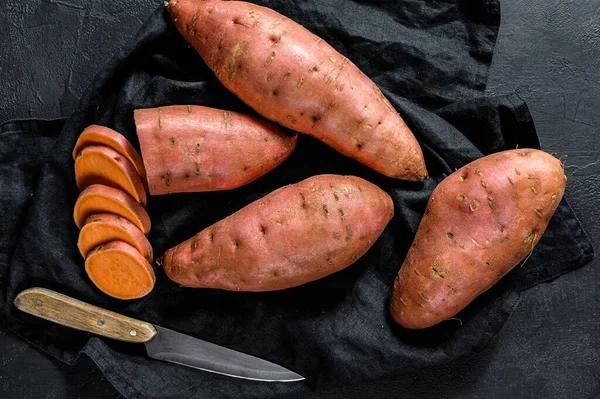 De l'igname crue, des batatas bio. La nourriture de la ferme. Fond noir — Photo