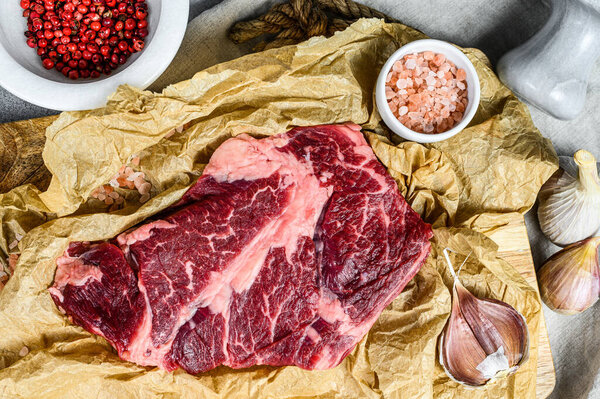 Raw beef steak on a chopping Board. Organic farm meat. Gray background.