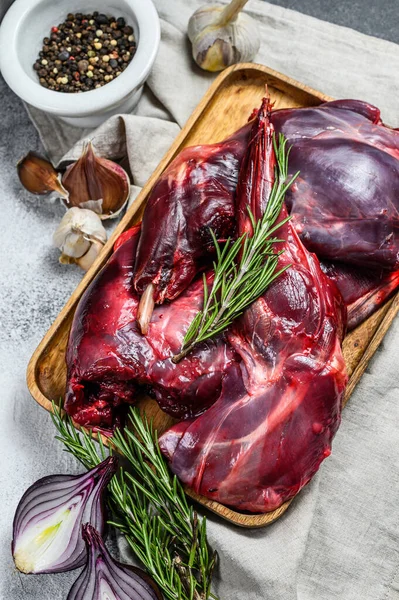 Viande de lapin. Lapin frais cru de ferme sur une table en bois avec des légumes et des épices. Vue de dessus. Viande biologique — Photo