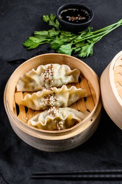Geleneksel bambu buharlı Japon gyoza 'sı. Üst Manzara. Köhne eski siyah arkaplan