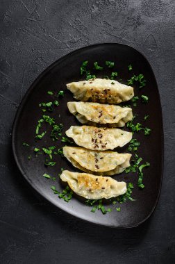 Kırsal siyah masada kızarmış Kore hamur köftesi tabağı. Dim sum tabakta. Üst görünüm