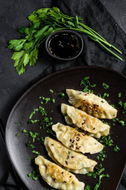 Kırsal siyah masada kızarmış Kore hamur köftesi tabağı. Dim sum tabakta. Üst görünüm