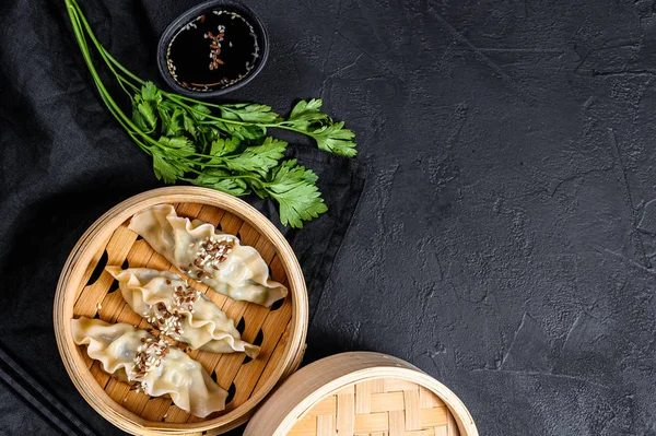 Koreańskie pierogi w tradycyjnym parowcu bambusowym. Widok góry. Miejsce na tekst. rustykalny stary vintage czarny tło — Zdjęcie stockowe