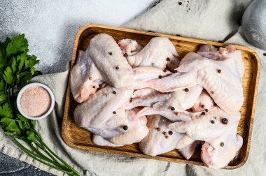 Tahta bir kasede çiğ tavuk kanadı. Üst Manzara. Gri arkaplan