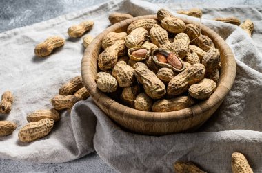 Kabuklu fıstıklar. Organik çiğ yer fıstığı. Gri arka plan. Üst Manzara. Metin için boşluk
