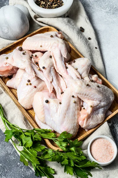 Tahta bir kasede çiğ tavuk kanadı. Üst Manzara. Gri arkaplan