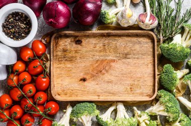 Pişmemiş sebzeler arasında tahta kesme tahtasının en üst görüntüsü. Ev vejetaryen mutfağı kavramı