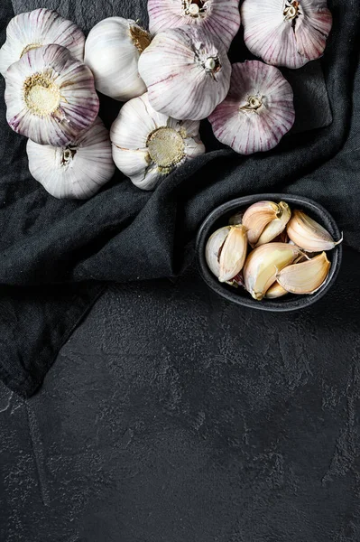 Garlic Bulb and garlic cloves on a wooden cutting Board. Organic farm food. Black background. Top view