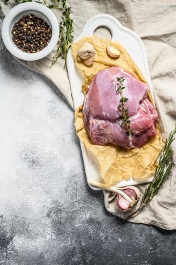 Seramik kesim tahtasında çiğ hindi filetosu. Çiftlik ekonomisi eti. Gri arka plan. Üst Manzara. Metin için boşluk.