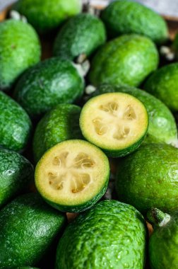 Ahşap bir tahtanın üzerinde yeşil feijoa. Gri arka plan. Üst Manzara. Kapat.