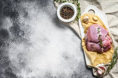 Seramik kesim tahtasında çiğ hindi filetosu. Çiftlik ekonomisi eti. Gri arka plan. Üst Manzara. Metin için boşluk.