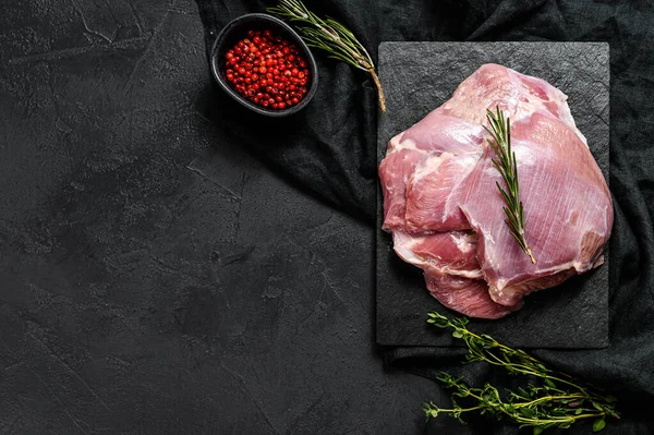 Raw Turkey thigh fillet. Farm eco meat. Dark background. Top view. Space for text.