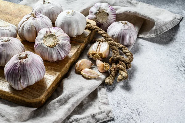 Garlic Bulb and garlic cloves on a wooden cutting Board. The concept of healthy eating. Gray background. Top view