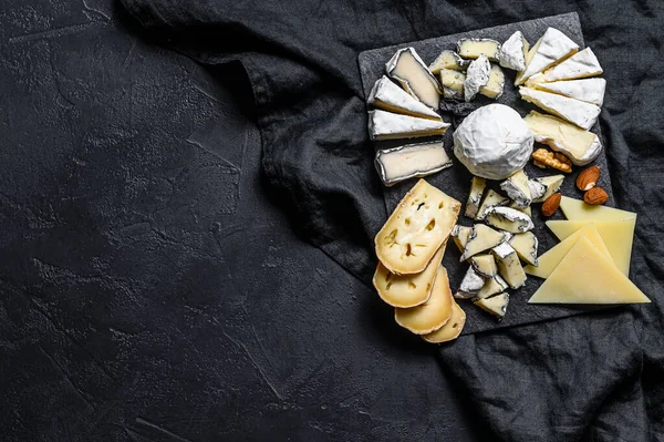 Plato de queso servido con nueces e higos. Fondo negro. Vista superior. Espacio para texto — Foto de Stock