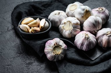 Taş bir tahtada sarımsak ve sarımsak. Organik tarım yiyeceği. Siyah arka plan. Üst Manzara. Kapat..