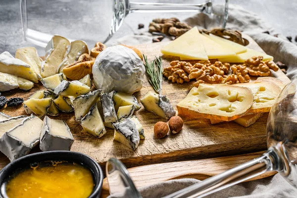 Sortimento de queijo francês com mel, nozes e figos na tábua de corte. Fundo cinzento. Vista superior . — Fotografia de Stock