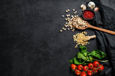 Humus malzemeleri, sarımsak, nohut, çam fıstığı, fesleğen, biber. Siyah arka plan. Üst Manzara. Metin için boşluk