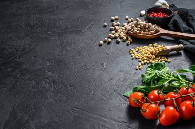 Humus malzemeleri, sarımsak, nohut, çam fıstığı, fesleğen, biber. Siyah arka plan. Üst Manzara. Metin için boşluk