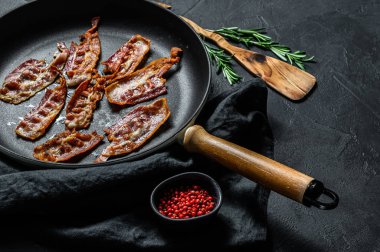 Tavada cızırtılı, çıtır çıtır pastırma pişirdim. Çiftlik organik eti. Siyah arka plan. Üst görünüm