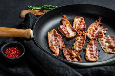 Kızarmış domuz pastırması dilimleri. Çiftlik organik eti. Siyah arka plan. Üst görünüm