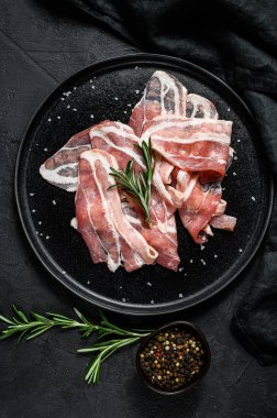 Siyah tabakta domuz pastırması. Çiftlik organik eti. Siyah arka plan. Üst görünüm