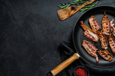 Tavada cızırtılı, çıtır çıtır pastırma pişirdim. Çiftlik organik eti. Siyah arka plan. Üst Manzara. Metin için boşluk