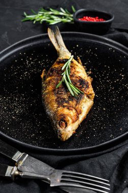 Beyaz bir tabakta fırında sazan balığı. Nehir organik balığı. Siyah arka plan. Üst Manzara. Metin için boşluk