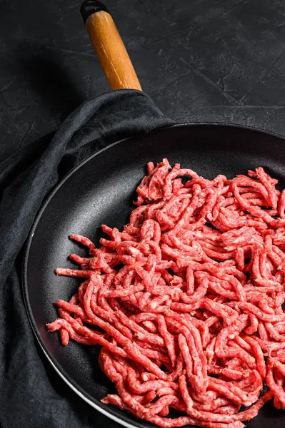 Raw minced marble beef in a frying pan. Black background. Top view — Stock Photo, Image