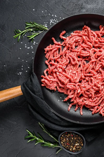 Minced beef in a frying pan. Farm organic meat. Black background. Top view — Stock Photo, Image