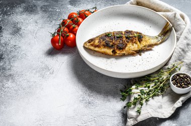 Beyaz tabakta kızarmış sazan balığı. Nehir organik balığı. Gri arka plan. Üst Manzara. Metin için boşluk